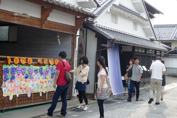 篠山幼稚園の園児が書いた作品を見る男女の写真